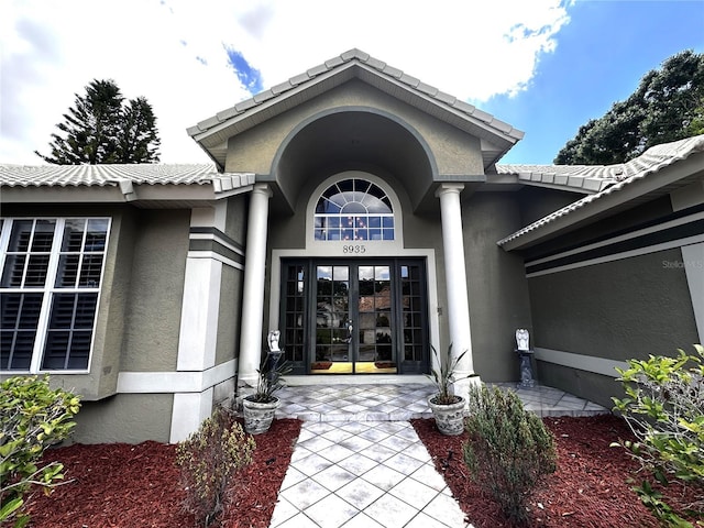 8935 Jonathan Manor Dr, Orlando, FL 32819 - view of exterior entry with french doors and stucco siding