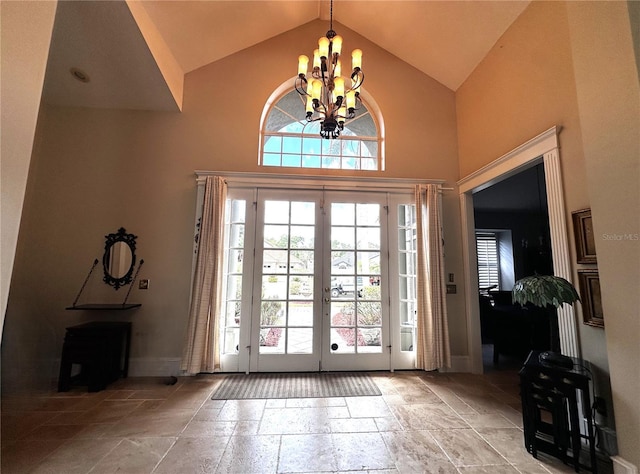 8935 Jonathan Manor Dr, Orlando, FL 32819 - doorway featuring baseboards, stone tile flooring, a chandelier, french doors, and high vaulted ceiling