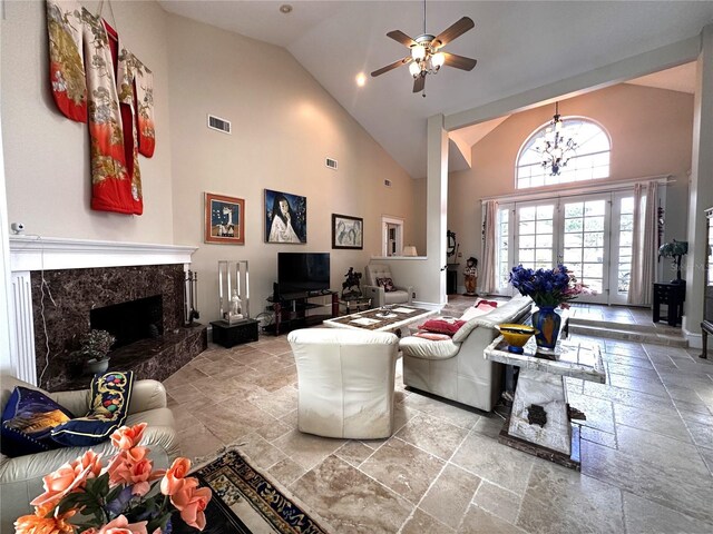 8935 Jonathan Manor Dr, Orlando, FL 32819 - living area with visible vents, stone tile flooring, a fireplace, ceiling fan with notable chandelier, and high vaulted ceiling