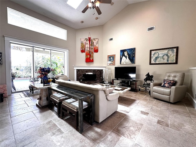 8935 Jonathan Manor Dr, Orlando, FL 32819 - living room with visible vents, high vaulted ceiling, a ceiling fan, and stone tile flooring