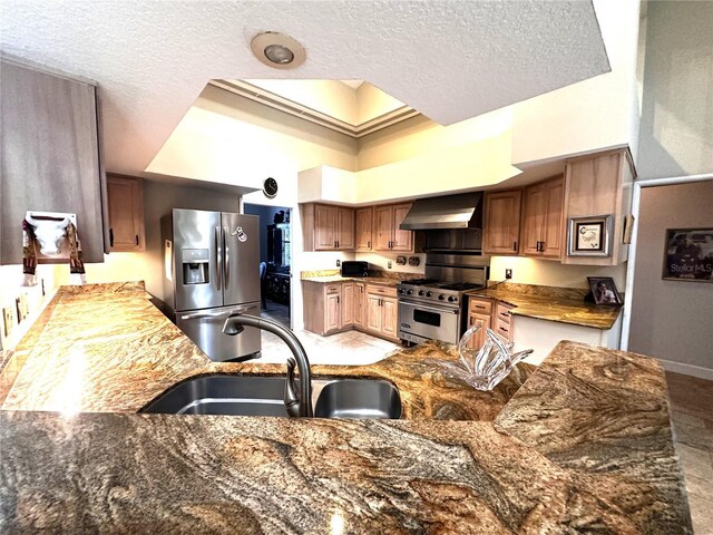 8935 Jonathan Manor Dr, Orlando, FL 32819 - kitchen with stone countertops, wall chimney range hood, a textured ceiling, stainless steel appliances, and a sink