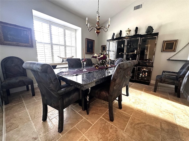8935 Jonathan Manor Dr, Orlando, FL 32819 - dining room featuring baseboards, an inviting chandelier, stone tile flooring, visible vents, and lofted ceiling