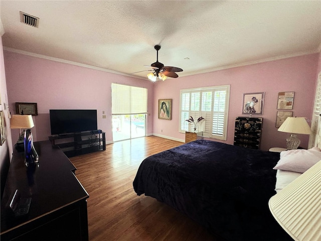 8935 Jonathan Manor Dr, Orlando, FL 32819 - bedroom with visible vents, baseboards, a textured ceiling, crown molding, and wood finished floors