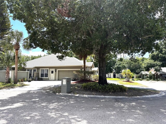 8935 Jonathan Manor Dr, Orlando, FL 32819 - view of front of home with a garage, driveway, and a tile roof