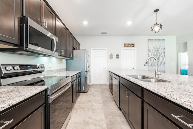 4231 Swan St, Haines City, FL 33844 - kitchen with dark brown cabinetry, light stone counters, visible vents, stainless steel appliances, and a sink