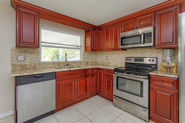 kitchen with stainless steel appliances, a sink, and reddish brown cabinets