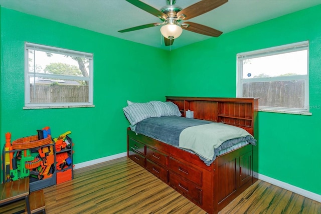 bedroom featuring wood finished floors, baseboards, and a ceiling fan