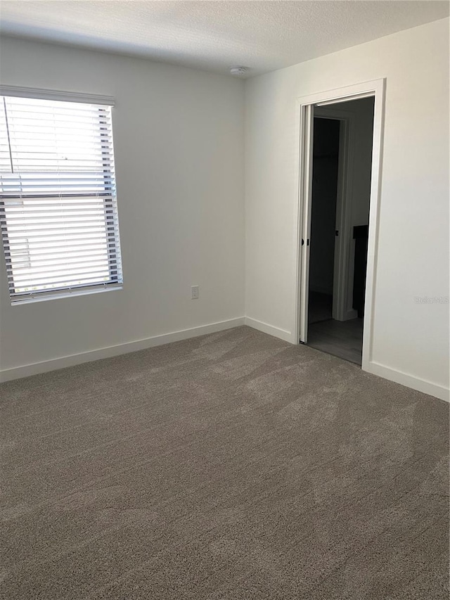 3432 Tranquil Trl, Kissimmee, FL 34747 - spare room with carpet floors, a textured ceiling, and baseboards