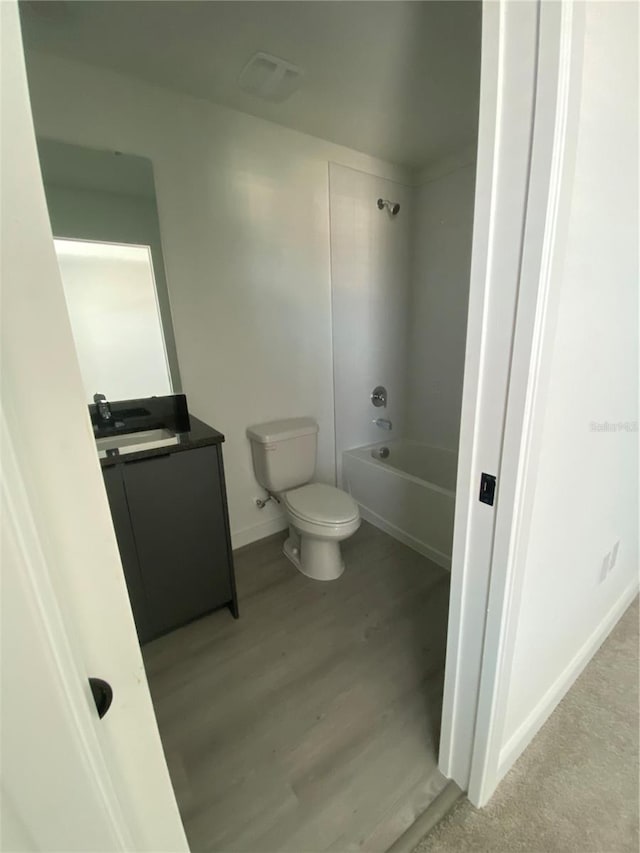 3432 Tranquil Trl, Kissimmee, FL 34747 - bathroom with toilet, vanity, washtub / shower combination, wood finished floors, and baseboards