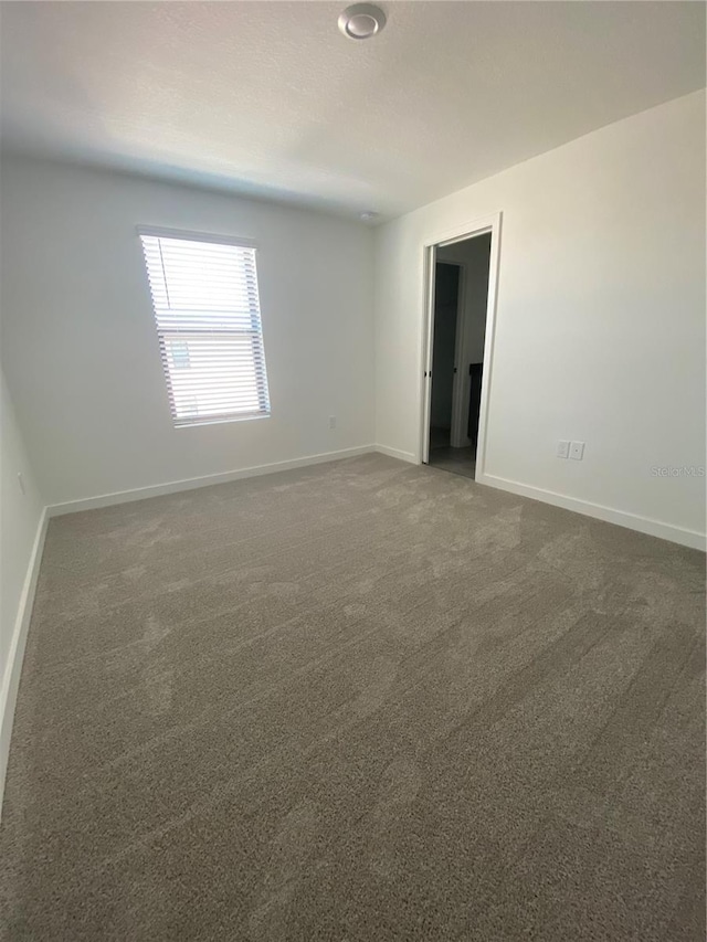 3432 Tranquil Trl, Kissimmee, FL 34747 - spare room with baseboards and dark colored carpet