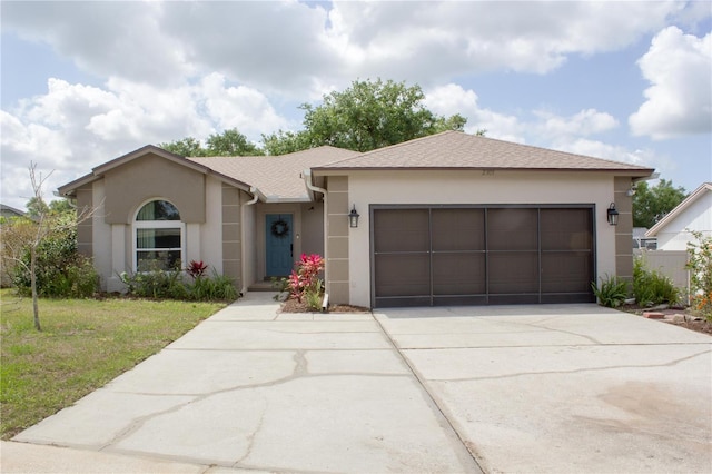 view of front facade featuring concrete driveway, stucco siding, an attached garage, and a front lawn