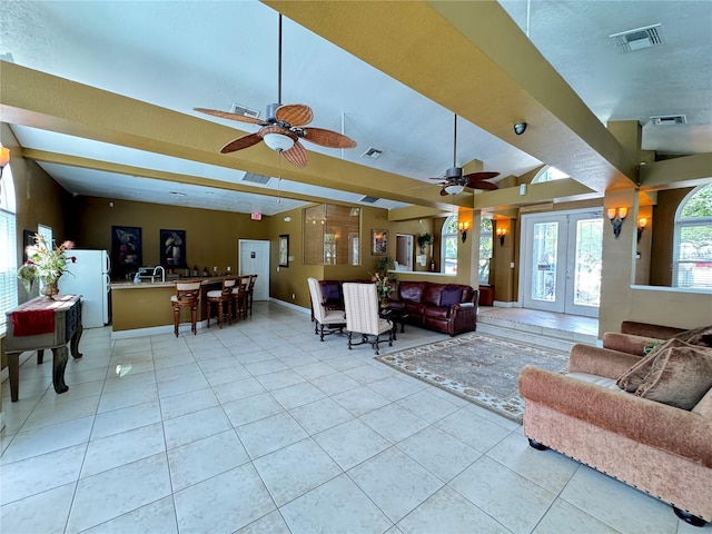living room featuring a ceiling fan, visible vents, and light tile patterned floors