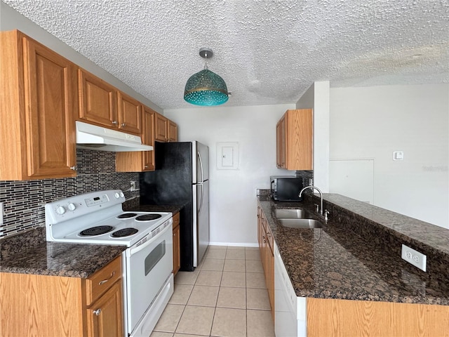 kitchen with under cabinet range hood, a sink, white appliances, and tasteful backsplash