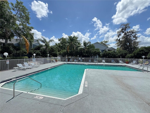 pool with a patio and fence