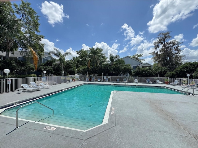 pool with fence and a patio area