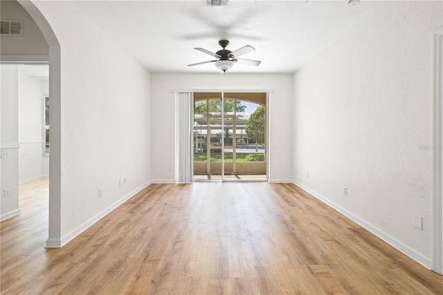 2484 San Tecla St Unit 106, Orlando, FL 32835 - unfurnished room with visible vents, baseboards, arched walkways, ceiling fan, and light wood-style floors