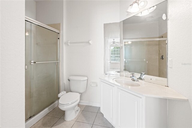 2484 San Tecla St Unit 106, Orlando, FL 32835 - bathroom featuring vanity, a textured wall, tile patterned flooring, toilet, and a shower stall