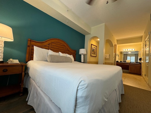 8125 Resort Village Dr Unit 51006, Orlando, FL 32821 - bedroom featuring arched walkways, light tile patterned flooring, and ensuite bathroom