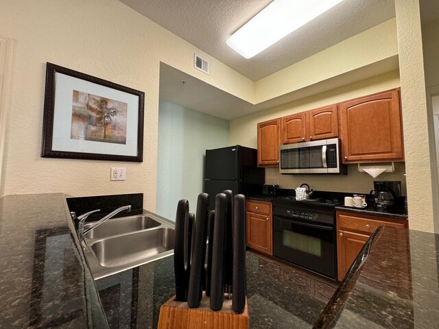 8125 Resort Village Dr Unit 51006, Orlando, FL 32821 - kitchen with a sink, a textured ceiling, stove, stainless steel microwave, and visible vents