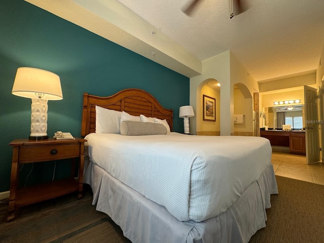 8125 Resort Village Dr Unit 51006, Orlando, FL 32821 - carpeted bedroom featuring arched walkways, ensuite bathroom, and tile patterned floors