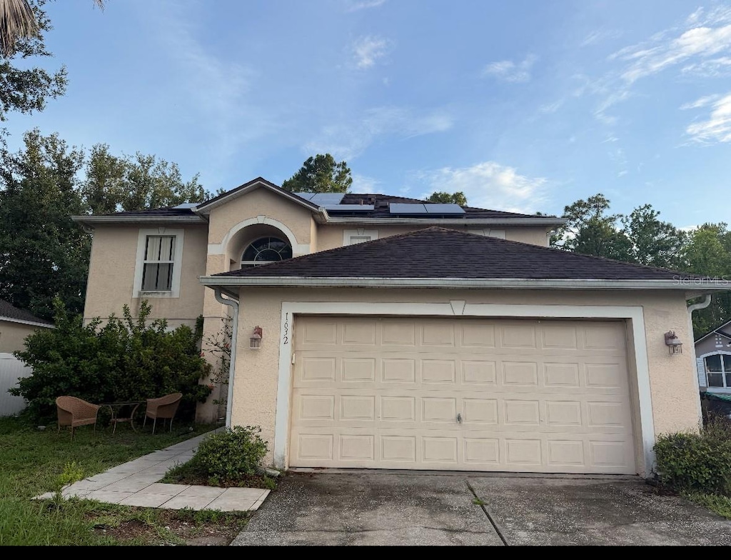 1632 Cornerview Ln, Orlando, FL 32820 - view of front of house featuring stucco siding, roof mounted solar panels, a garage, and driveway