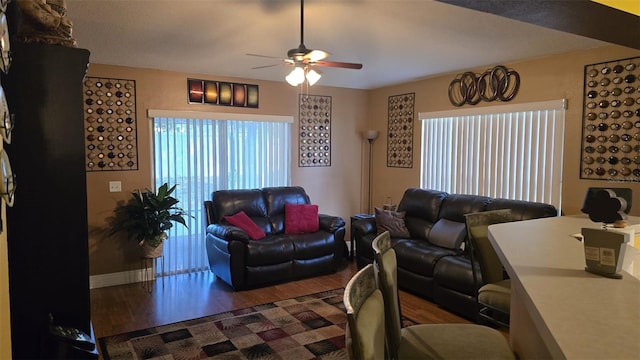 living room featuring baseboards, a ceiling fan, and wood finished floors