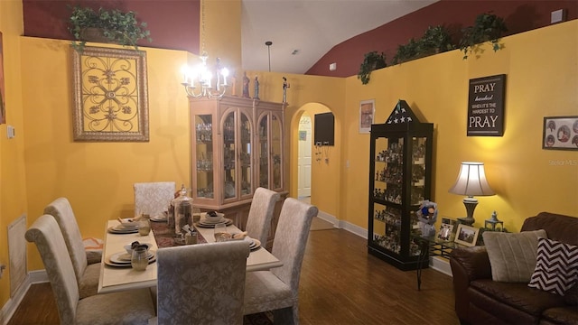 dining room featuring arched walkways, wood finished floors, lofted ceiling, baseboards, and a notable chandelier