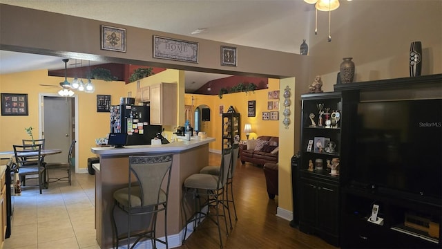 kitchen with ceiling fan, vaulted ceiling, and freestanding refrigerator