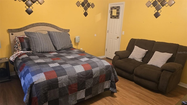 bedroom with baseboards and wood finished floors