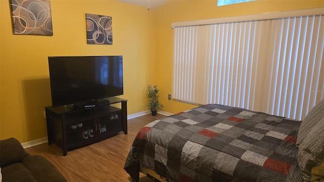 bedroom with baseboards and wood finished floors