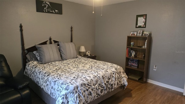 bedroom featuring baseboards and wood finished floors