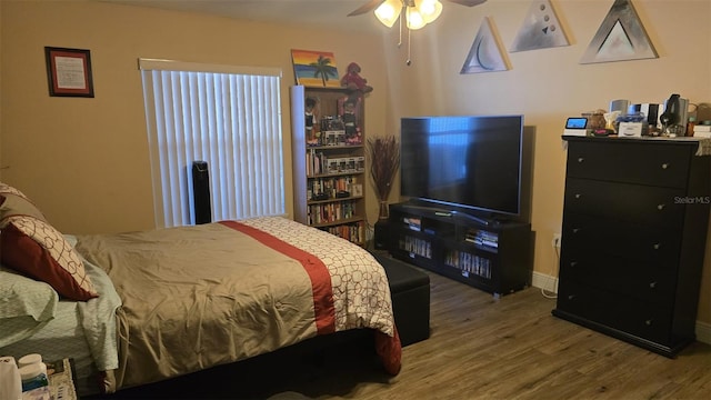 bedroom featuring ceiling fan, baseboards, and wood finished floors