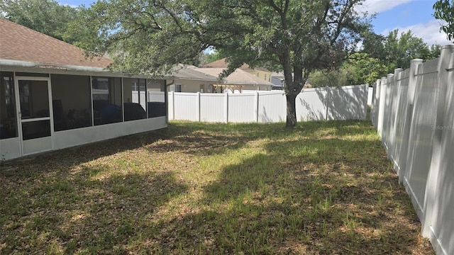 view of yard featuring a sunroom and a fenced backyard