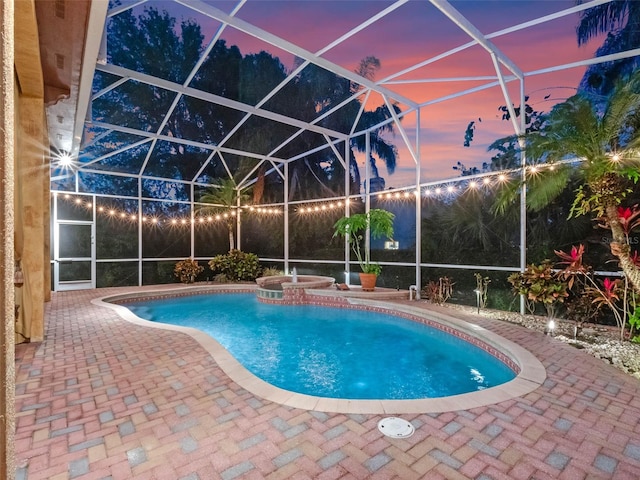pool with a patio area, an in ground hot tub, and a lanai