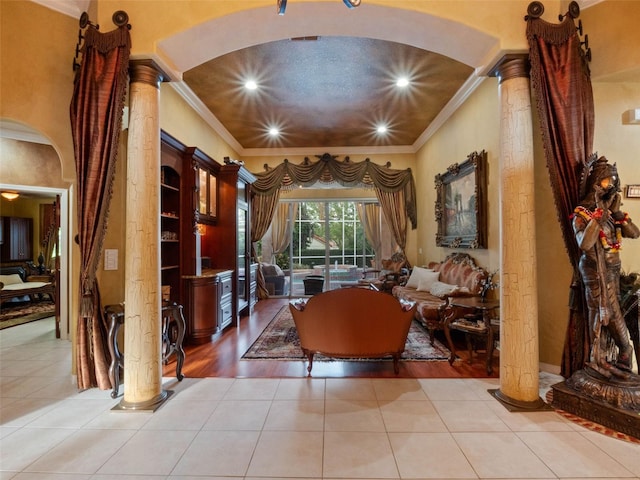 living area featuring tile patterned floors, ornate columns, and arched walkways