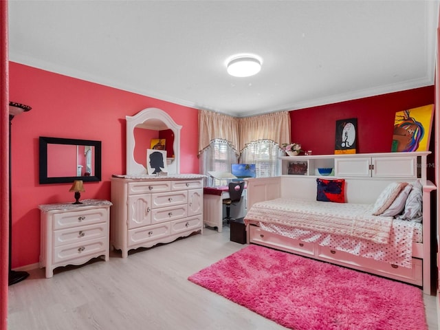 bedroom with ornamental molding and light wood-style flooring