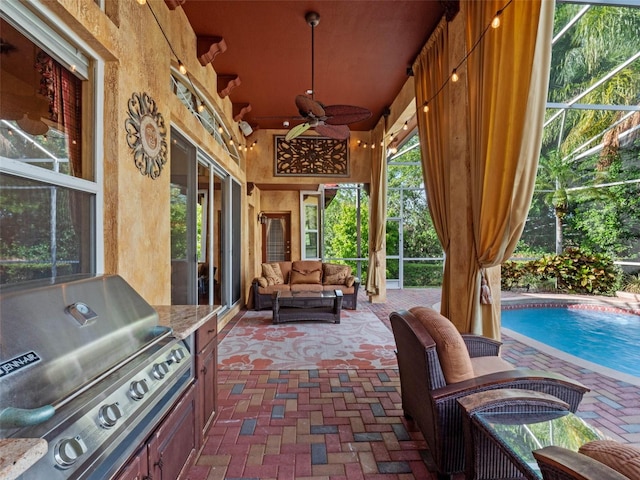 view of patio with an outdoor living space, an outdoor kitchen, ceiling fan, a grill, and glass enclosure