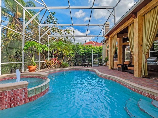 view of pool featuring a patio area, a pool with connected hot tub, a grill, and a lanai