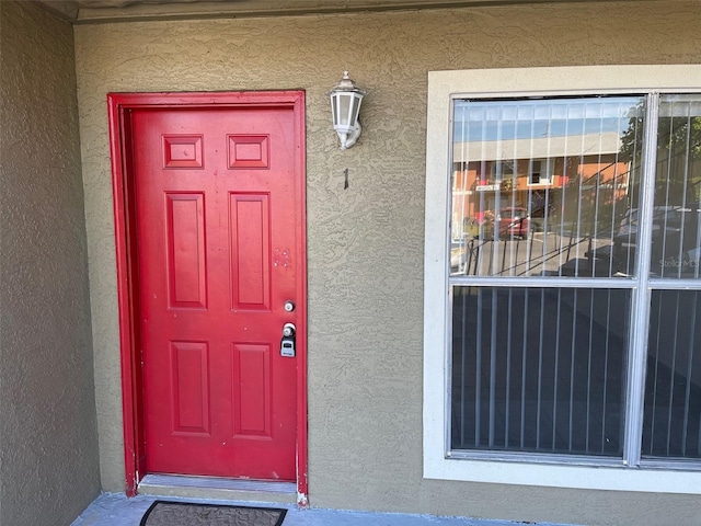 property entrance with stucco siding