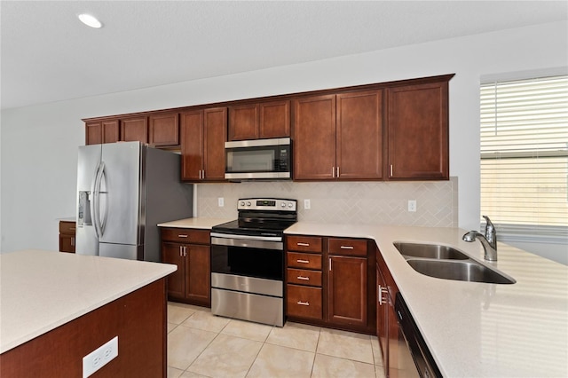 kitchen featuring light countertops, stainless steel appliances, tasteful backsplash, and a sink