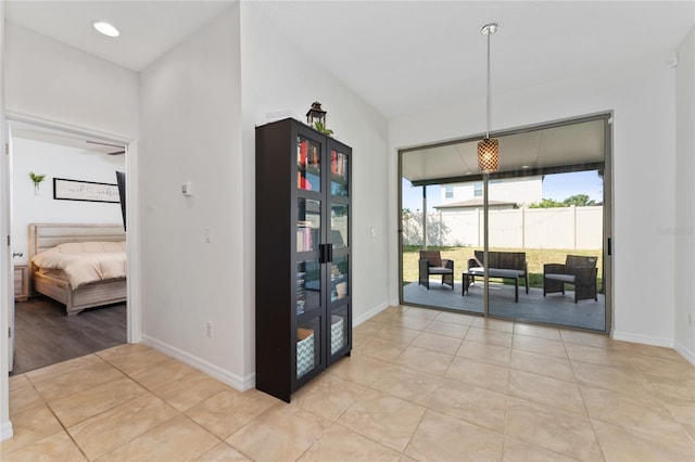 hall featuring light tile patterned floors and baseboards