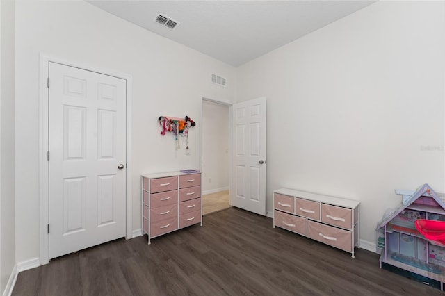 bedroom featuring baseboards, dark wood-style flooring, and visible vents