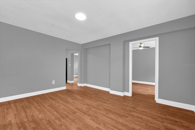 spare room featuring baseboards and wood finished floors