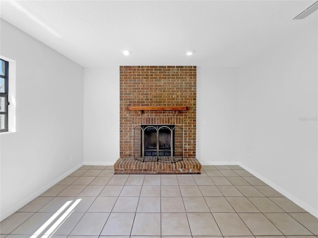 unfurnished living room featuring visible vents, baseboards, a brick fireplace, and light tile patterned floors