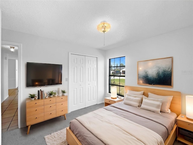 carpeted bedroom with a closet and a textured ceiling