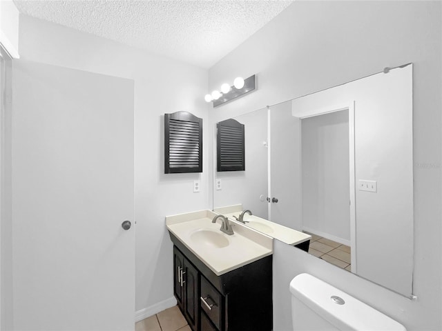 bathroom with baseboards, toilet, a textured ceiling, vanity, and tile patterned floors