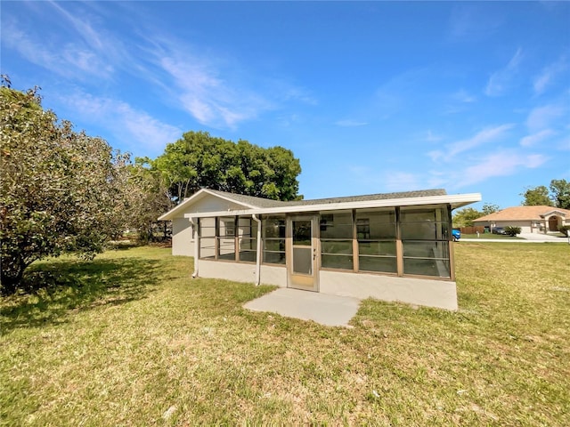 rear view of property with a yard and a sunroom