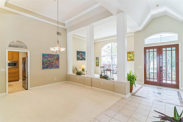 foyer entrance featuring light tile patterned floors, a healthy amount of sunlight, and a high ceiling