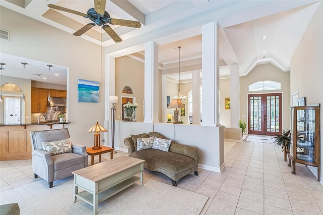 living area with french doors, visible vents, a ceiling fan, light tile patterned flooring, and high vaulted ceiling