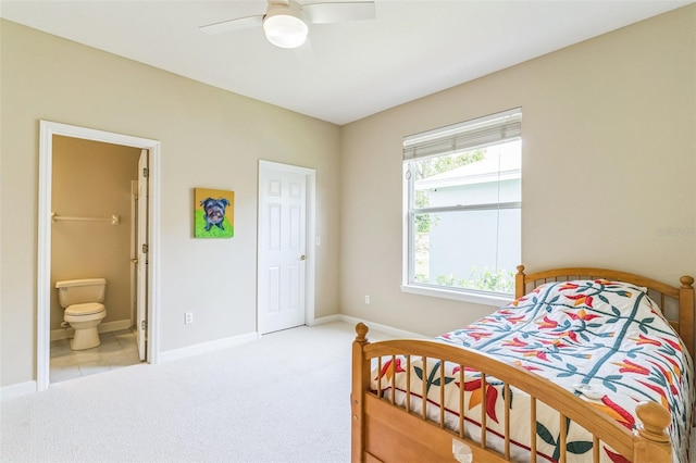 bedroom with carpet, connected bathroom, a ceiling fan, and baseboards